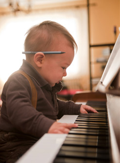 Toddler hand and piano keyboard.
